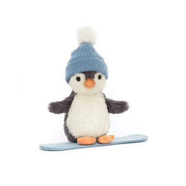 A plush snowboarding penguin set against a white background. The Penguin is wearing a blue winter beanie with a white pom on top!